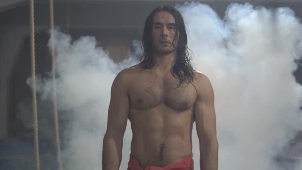 Male athlete, model with long hair, beautiful body in weight training, posing - Video, Çekim