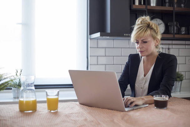 Une jeune femme concentrée travaillant sur le démarrage d'une petite entreprise avec un ordinateur portable
. - Photo, image