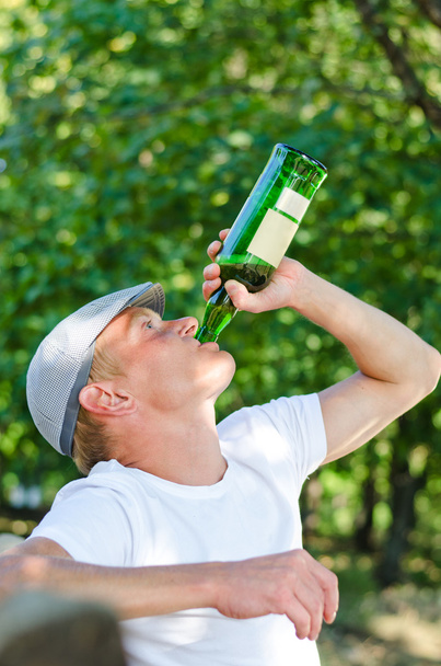 Зависимый мужчина средних лет, пьющий белое вино
 - Фото, изображение