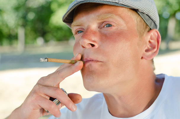 Homem pensativo de meia-idade fumando no parque
 - Foto, Imagem