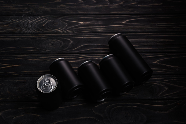 musta alumiini tölkit olutta puinen pöytä kopioi tilaa
 - Valokuva, kuva