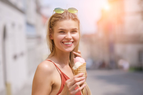 Cheerful girl eating ice cream cone - Fotoğraf, Görsel