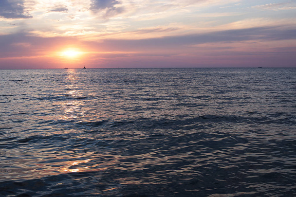 海の明るい夕日は、空気と水の多くは狭い海岸線、空に太陽の色の勾配のアクアの近くに夜明け - 写真・画像