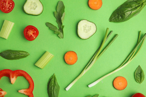 Flat lay composition with fresh ingredients for salad on green background - 写真・画像