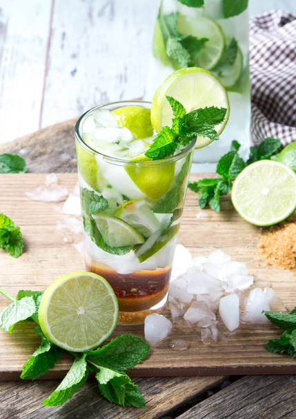 Mohito lime drinks on wooden with blur beach background. Fresh drinks with fruits on wood. Summer concept - Zdjęcie, obraz