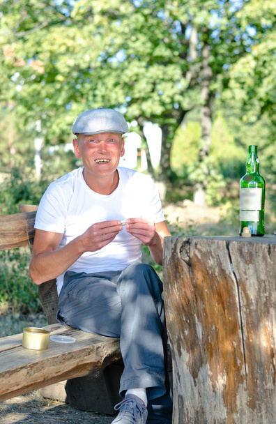 Uomo felice che fuma e beve nel bosco
 - Foto, immagini