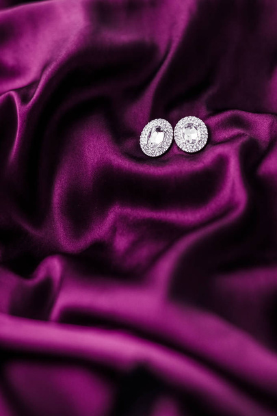 Luxury diamond earrings on dark pink silk fabric, holiday glamou - Photo, Image