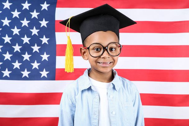 Schattige jongen in Graduation Cap op Amerikaanse vlag achtergrond - Foto, afbeelding