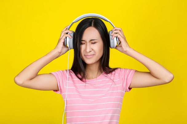 Beautiful woman with headphones on yellow background - Foto, Bild