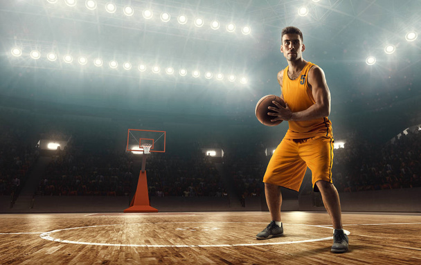 Παίκτης μπάσκετ με τη μπάλα σε ένα επαγγελματικό γήπεδο μπάσκετ με φωτισμό - Φωτογραφία, εικόνα