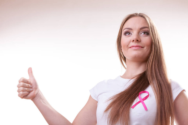 woman pink cancer ribbon on chest making thumb up - Photo, Image