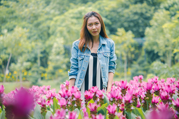 A woman standing in a pink flower garden - Photo, Image