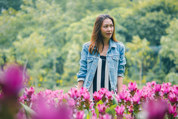 Kobieta stoi w różowym ogrodzie kwiat - Zdjęcie, obraz
