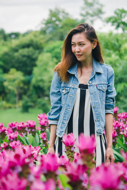 Una donna in piedi in un giardino di fiori rosa
 - Foto, immagini