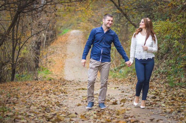 Young couple walking through the park. Autumn, fall romantic concept - Zdjęcie, obraz