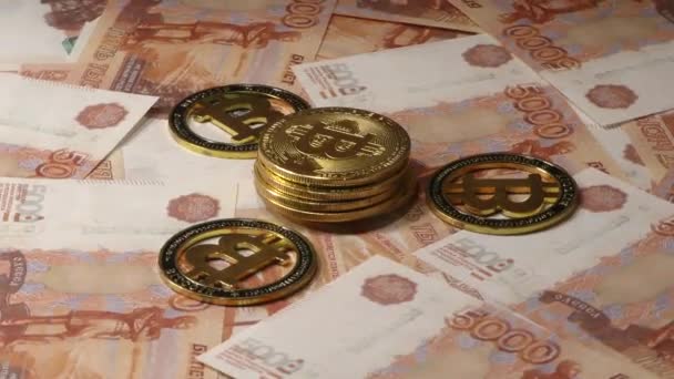 Bitcoin BTC monety obracające się na rachunki 5000 rubli rosyjskich. Światowa kryptowaluta na całym świecie. - Materiał filmowy, wideo