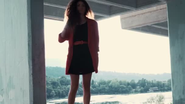 Mujer con chaqueta roja camina nerviosa mientras espera a alguien
 - Metraje, vídeo