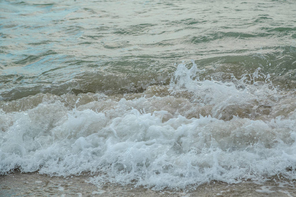 sfondo di onde che battono su una spiaggia sabbiosa in tempo tempestoso
 - Foto, immagini