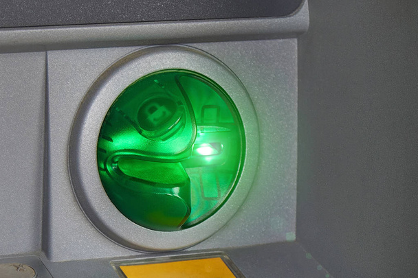 Kulatý zelený slot ATM pro debetní a kreditní karty zblízka. Zelené podsvícení. Bezpečné kancelářské transakce, převody peněžních prostředků, výběry hotovosti, platby za služby a zboží online. - Fotografie, Obrázek
