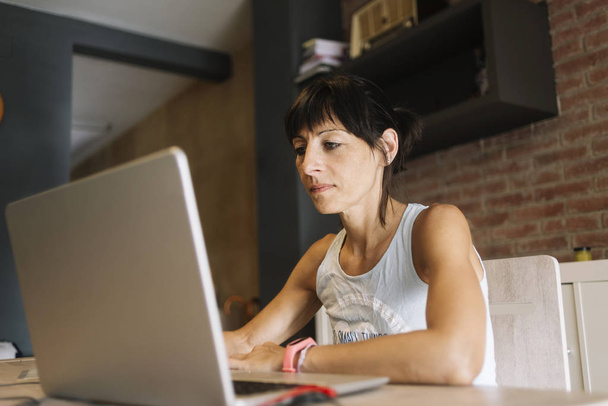 Woman with laptop working at home - Foto, Bild