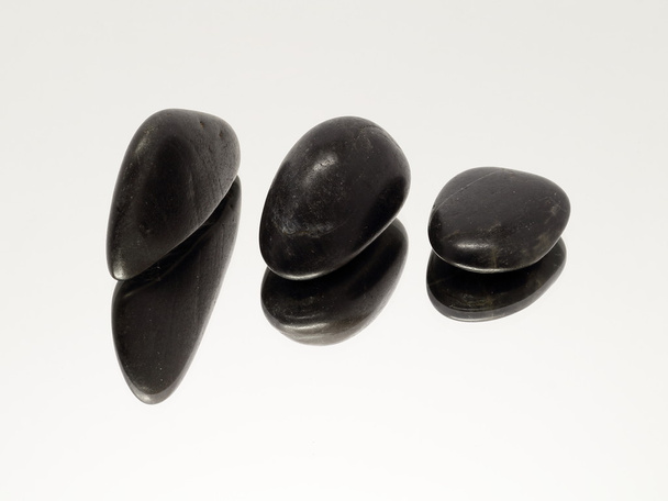 Three lava stones onn mirror - Foto, imagen