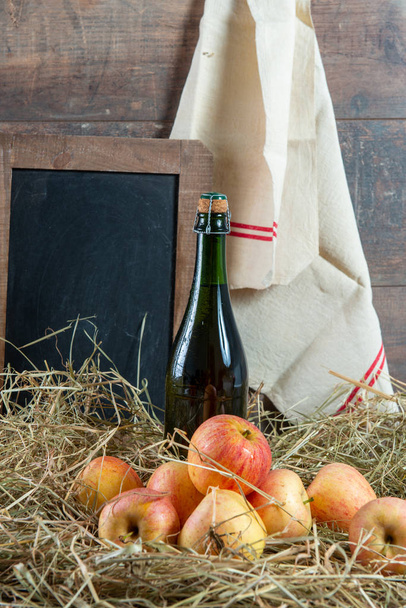 Üveg almabor almával a szalmán, és az iskolai palatboard - Fotó, kép