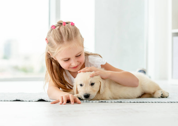 Little girl hugging retriever puppy - Foto, immagini