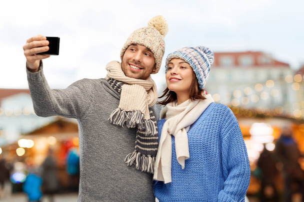 couple takes selfie by smartphone christmas market - Foto, Imagen