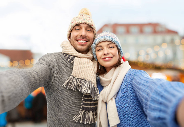 happy couple taking selfie at christmas market - Foto, imagen