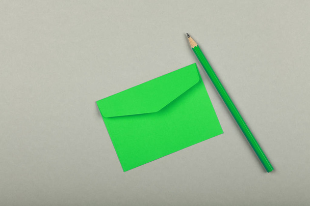 ZAMKNIĘTA Zielona koperta papierowa na szaro - Zdjęcie, obraz