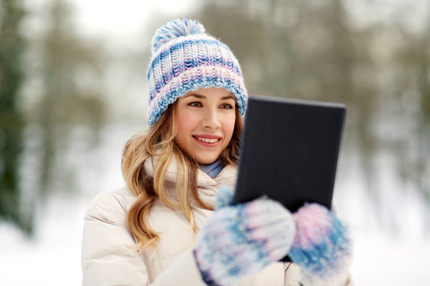 woman with tablet computer outdoors in winter - Фото, изображение