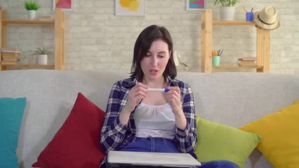 young joyful woman with a positive pregnancy test in her hands - Felvétel, videó