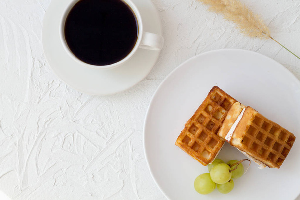 ontbijt met kopje koffie en Belgische wafels op witte achtergrond top uitzicht. - Foto, afbeelding