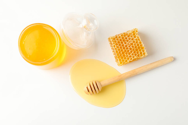 Jar with honey, dipper and honeycomb on white background, copy s - Valokuva, kuva