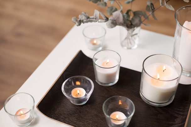 kaarsen en takken van eucalyptus op tafel - Foto, afbeelding