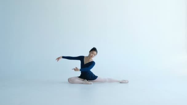 νέος χορεύτρια μπαλέτο κάθεται μισό-σπάγκο κινούμενα χέρια στο χορό - Πλάνα, βίντεο