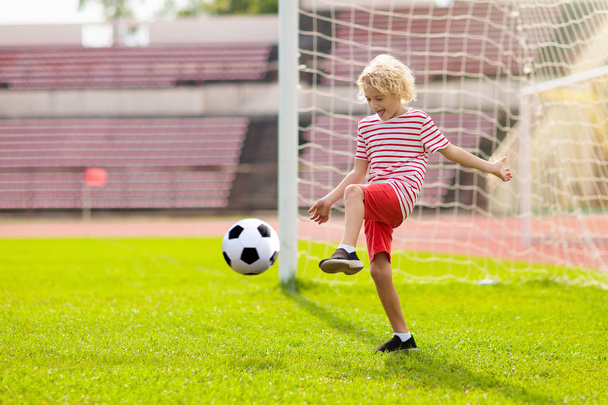 Τα παιδιά παίζουν ποδόσφαιρο. Παιδί στο γήπεδο ποδοσφαίρου. - Φωτογραφία, εικόνα