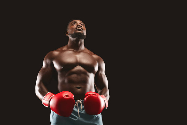 Concentrated black boxer preparing himself for fight - Photo, Image