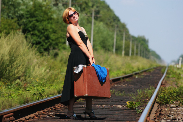 girl on the railroad track with suitcase - Photo, Image