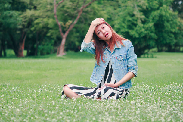 Длинноволосая женщина, сидящая на газоне
 - Фото, изображение