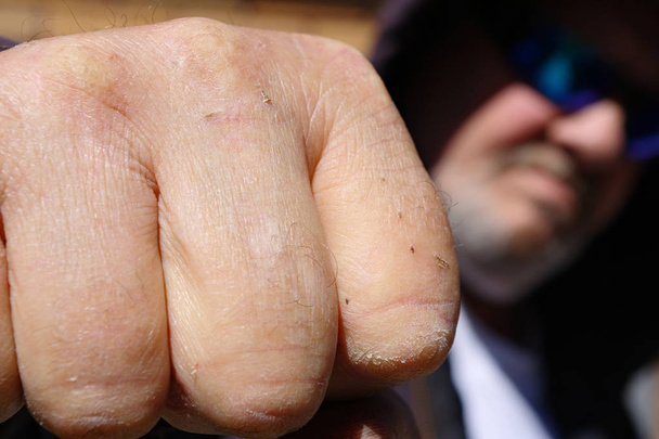 Le poing d'un homme avec son visage flou en arrière-plan
 - Photo, image