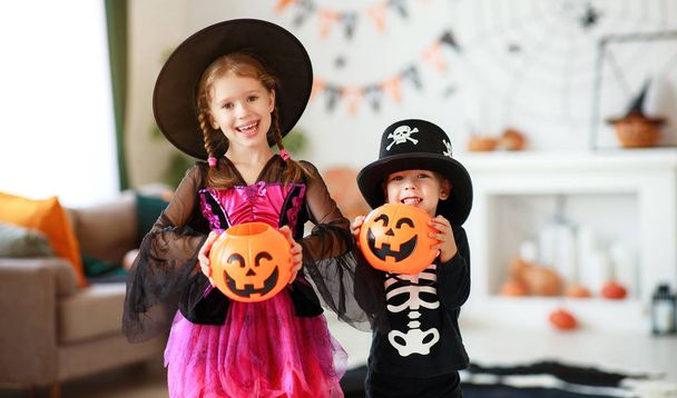 Feliz Halloween! dos niños en trajes y con calabazas en casa
 - Foto, Imagen