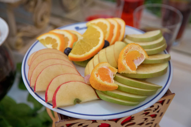 Pomme rouge, orange, poire, kiwi, raisin. fruits tranchés sont à l'intérieur de l'assiette
. - Photo, image