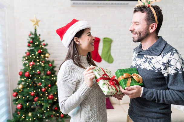 Amateurs de milieu adulte échangeant des cadeaux à la maison pendant Noël
 - Photo, image