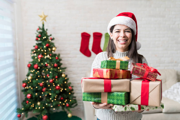 gut aussehende Frau mit Geschenken im heimischen Wohnzimmer zu Weihnachten - Foto, Bild