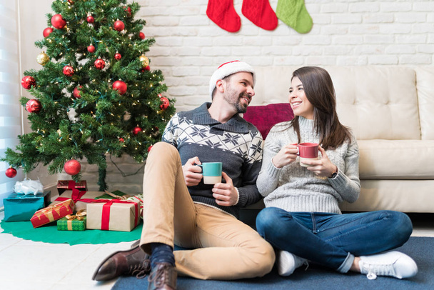 Evde Noel sırasında konuşurken kahve içen neşeli çift - Fotoğraf, Görsel