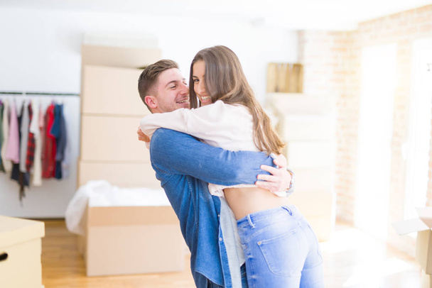 Beautiful young couple hugging in love, very happy moving to a new home - 写真・画像