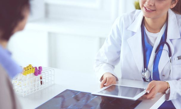 Ärztin mit Tablet-Computer in Krankenhauslobby, lächelnd - Foto, Bild