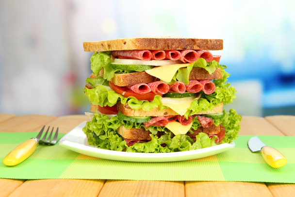 Huge sandwich on wooden table, on light background - Valokuva, kuva