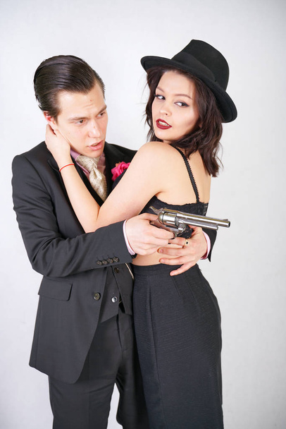 man in classic costume with gun protect his girlfriend on white studio background - Photo, Image